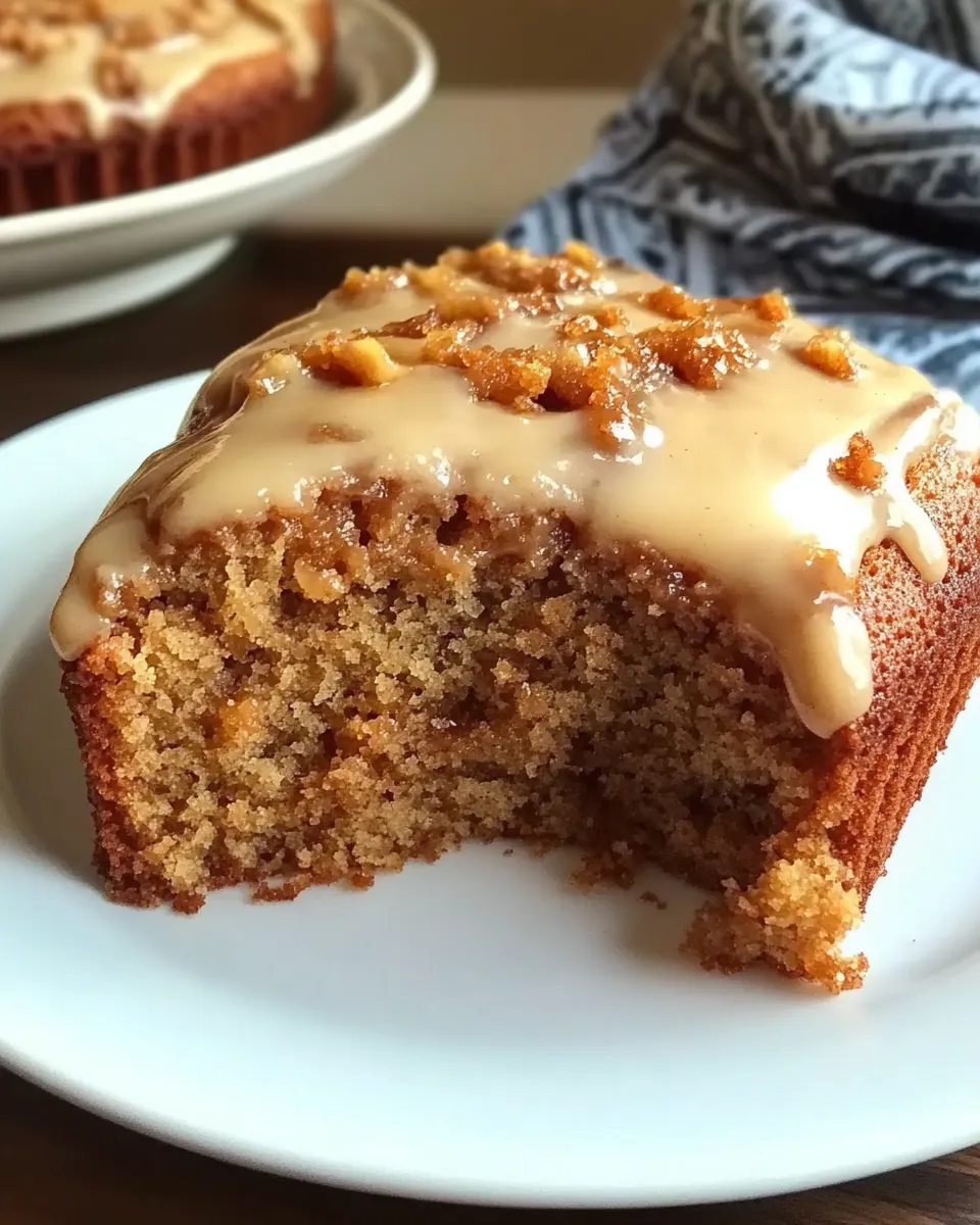 A slice of applesauce cake on a white plate.
