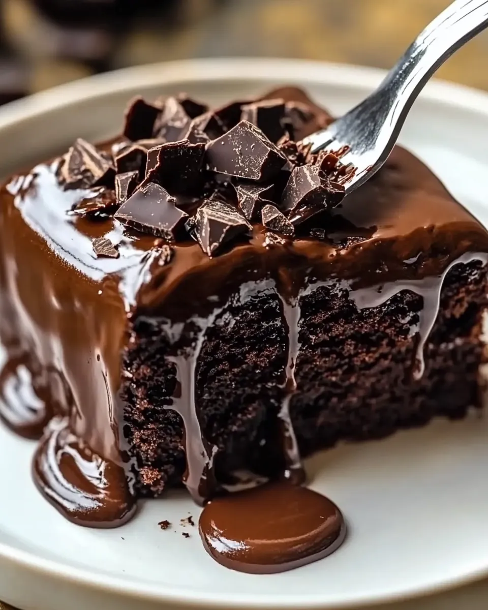 A slice of chocolate cake with chocolate drizzle.