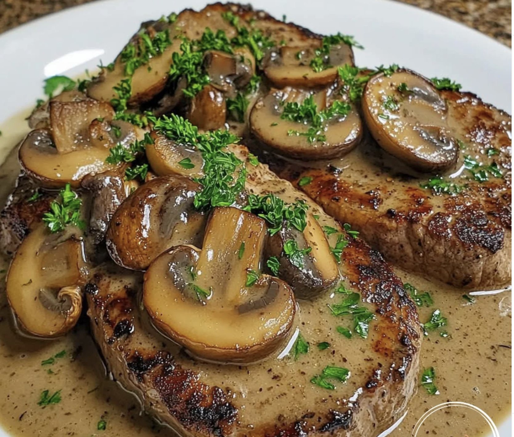 A plate of meat with mushrooms on top.
