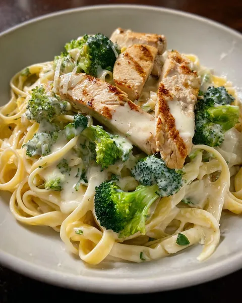 A plate of pasta with chicken and broccoli.