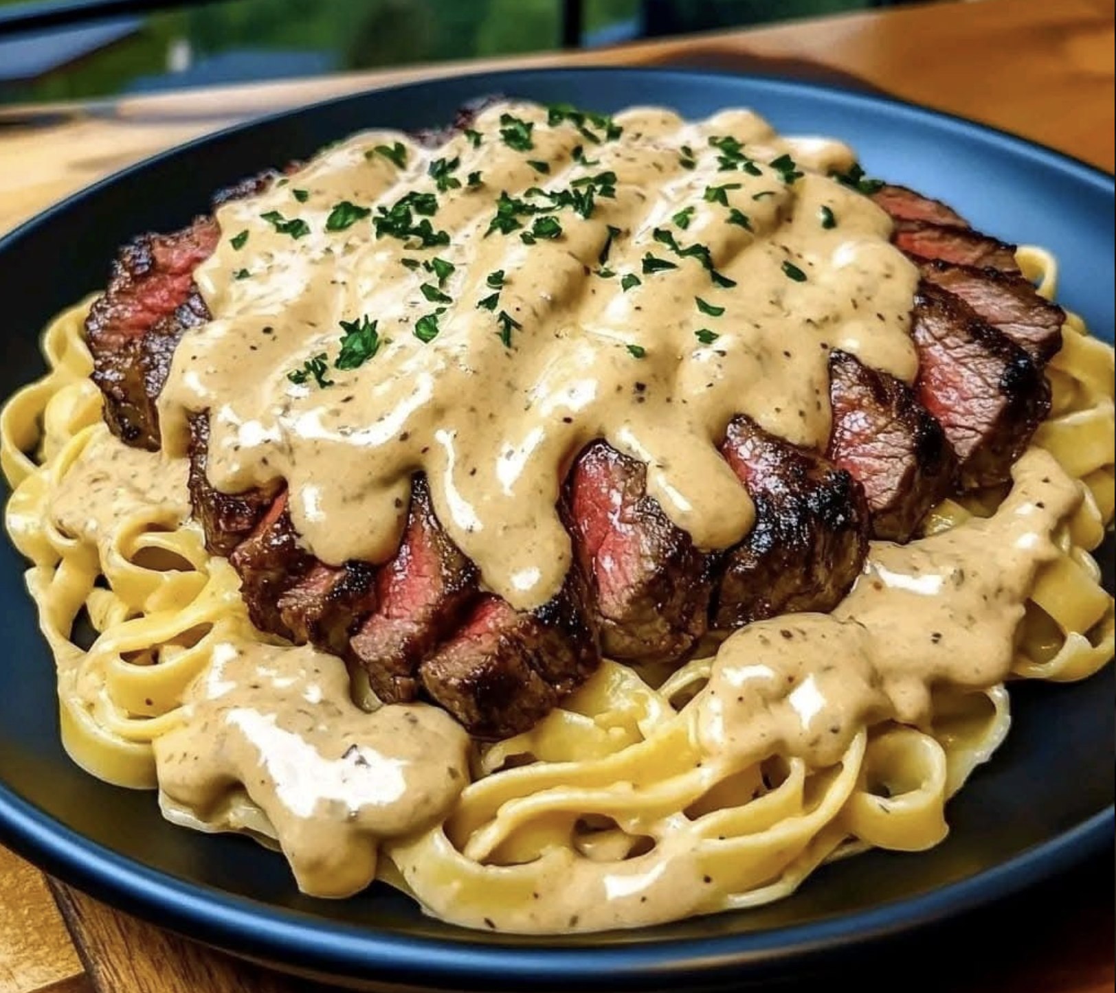 A plate of food with a steak covered in sauce.