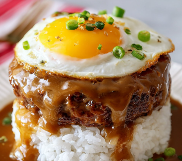 A fried egg on top of a piece of meat.