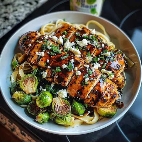 A plate of food with chicken, pasta, and vegetables.