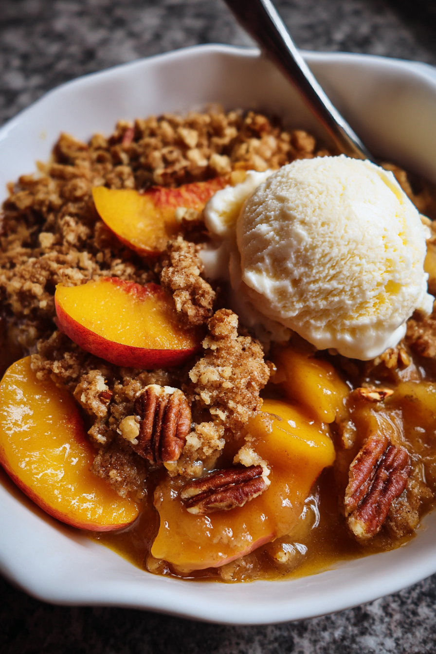 A bowl of fruit with a scoop of ice cream on top.