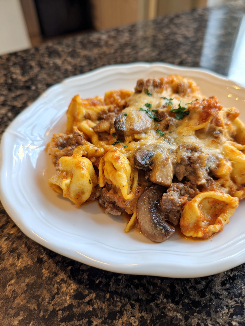 A plate of pasta with meat and mushrooms.