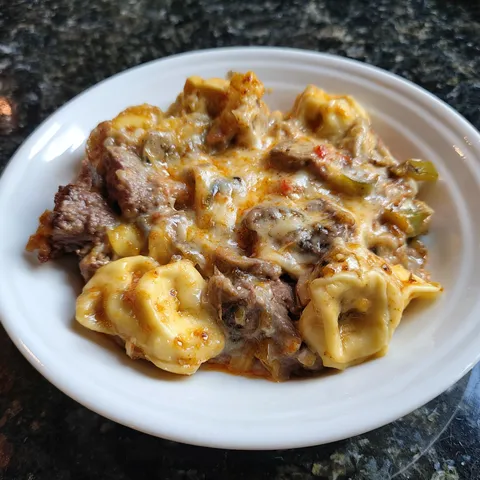 A plate of food with meat and pasta.