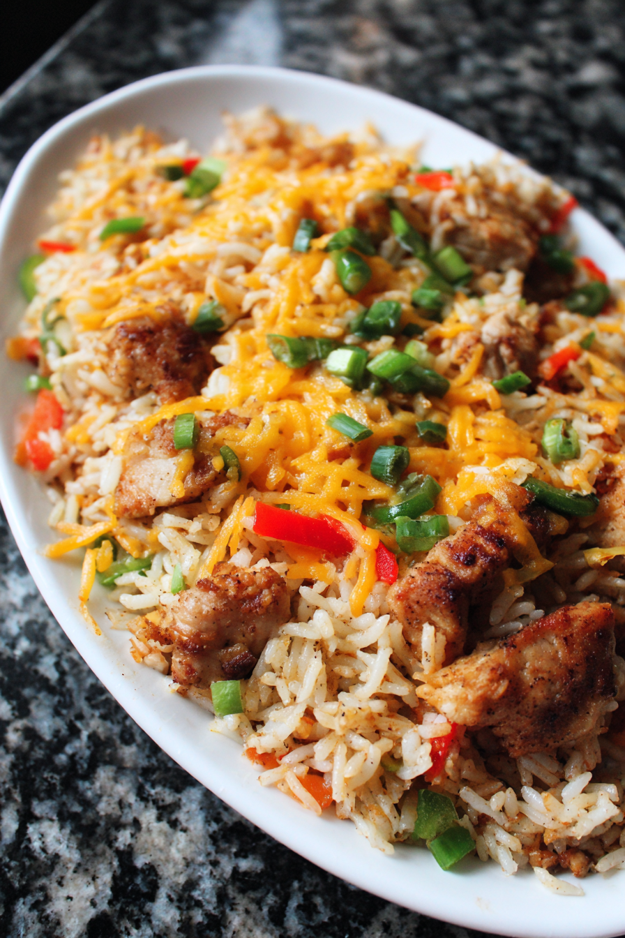 A plate of rice with chicken and peppers.