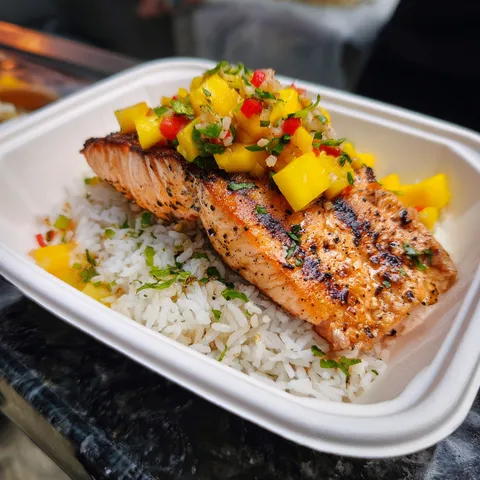 A white bowl with rice and fish.