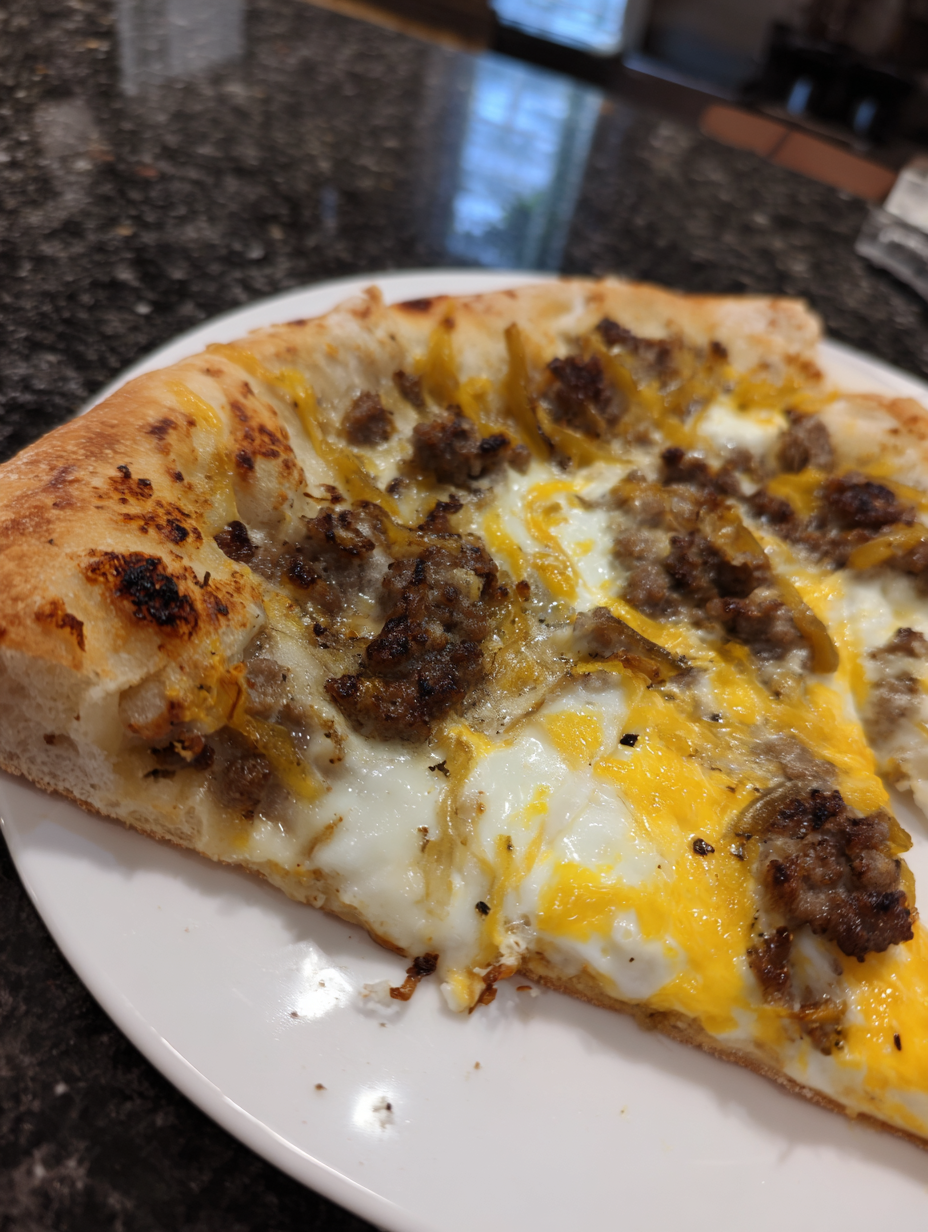A slice of pizza with meat and cheese on a white plate.