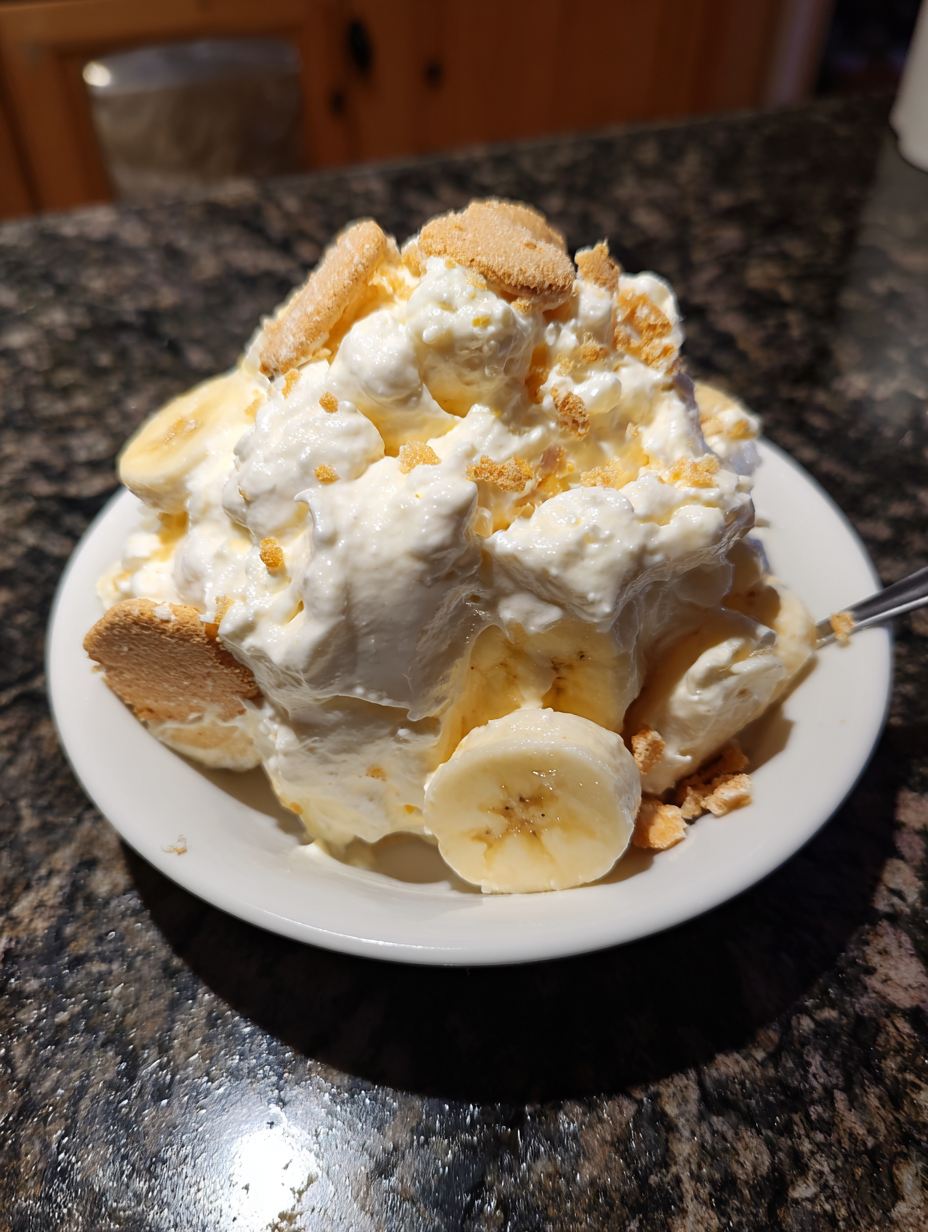 A white plate with a banana split on it.