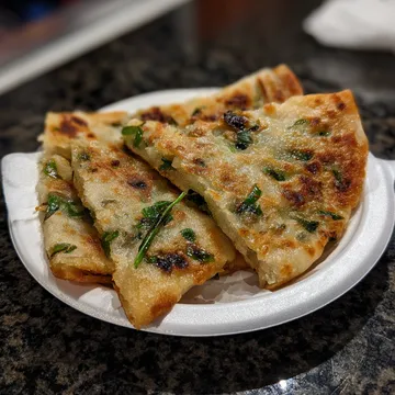 A white plate with two pieces of food on it.