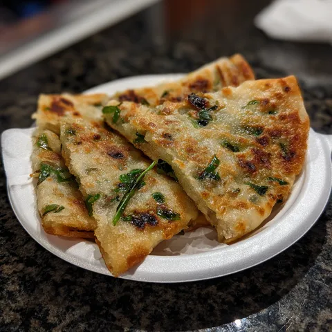 A white plate with two pieces of food on it.