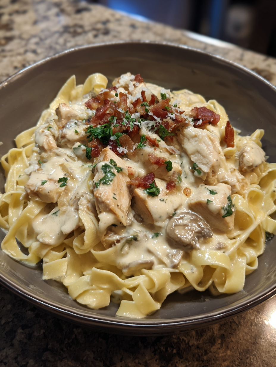 A bowl of pasta with chicken and bacon.