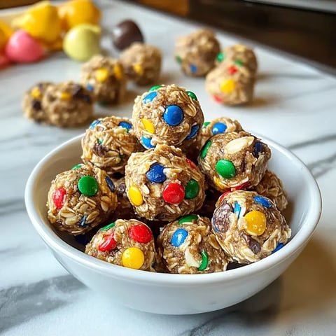 A bowl filled with colorful oatmeal energy balls featuring assorted chocolate and candy-coated pieces.